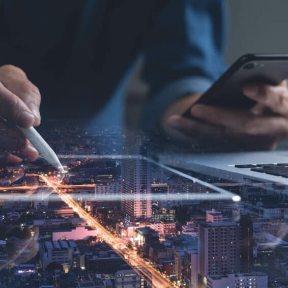 Person working on a tablet and laptop and phone.